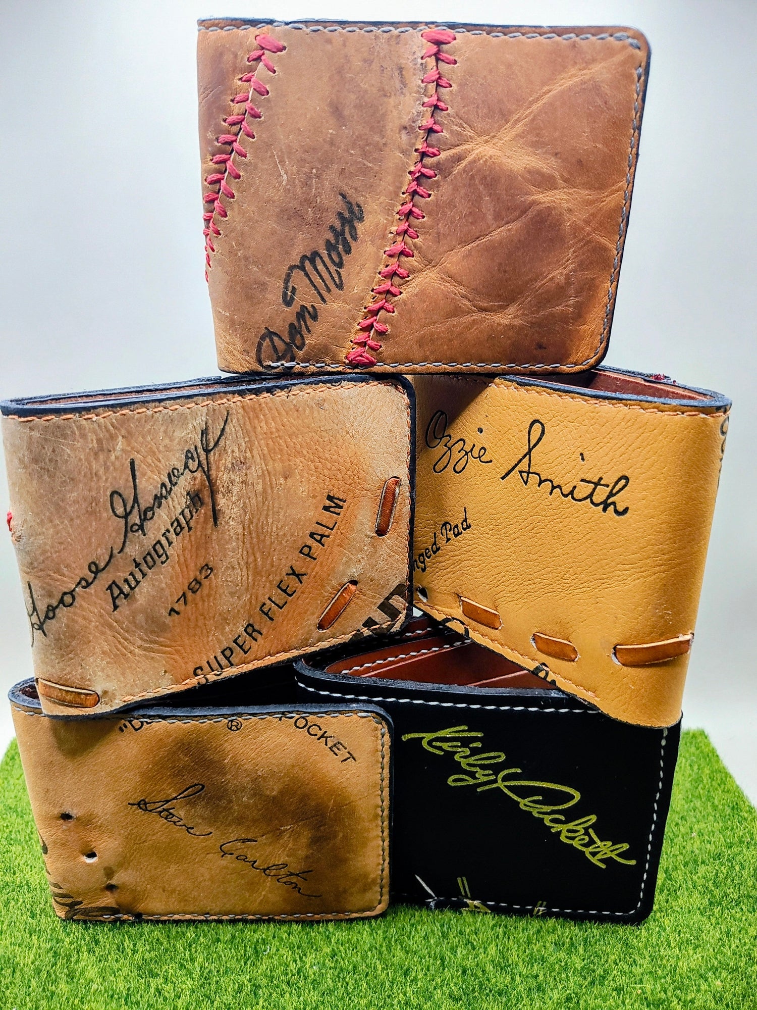 Several wallets with baseball player signatures made from baseball gloves